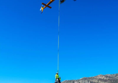 Helicopter in the sky hauling two people