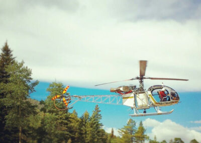 White helicopter over the forest