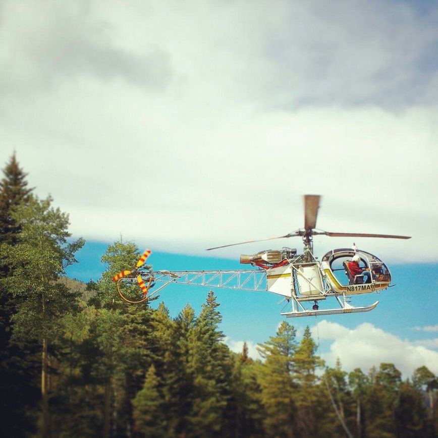 White helicopter over the forest