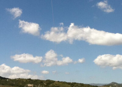 Yellow helicopter in the sky hauling items