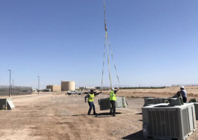 Men hooking up an item to be hauled by helicopter