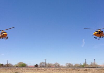 Two yellow helicopters in the sky