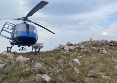 Blue helicopter on top of the mountains