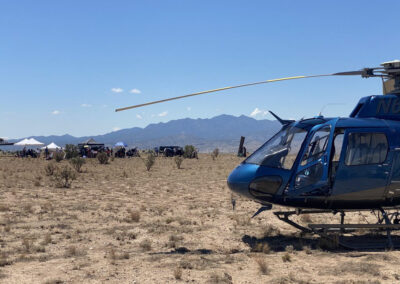 Helicopter in the desert with film crew in the background