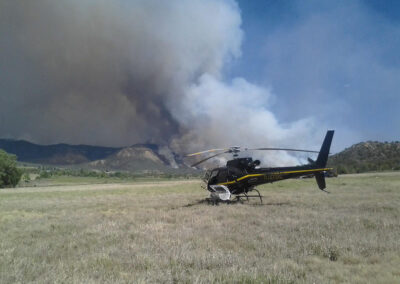 Helicopter with wildfires in the mountains in the background