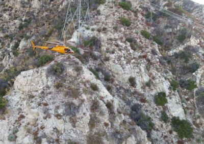 Yellow helicopter flying over the mountains