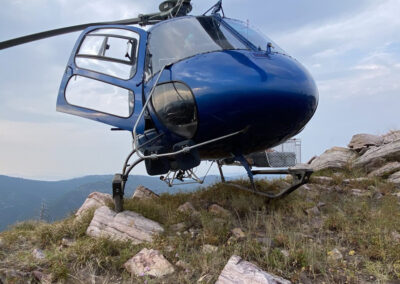 Blue helicopter on top of the mountains